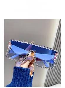 Detail of oversized square blue sunglasses with rhinestone frame and gemstone accents