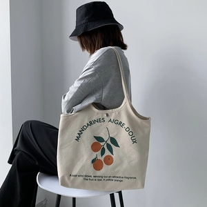 Détail du grand sac cabas en toile avec motif orange et fermeture par bouton-pression