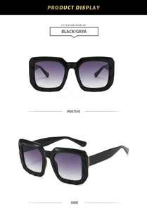 Detail view of thick black square sunglasses with unique geometric texture and purple gradient lenses