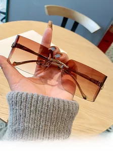 Detail of rimless square sunglasses with brown gradient lenses and gold leopard metal accent