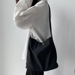 Minimalist black nylon tote bag with large capacity and silver metal buckle on strap