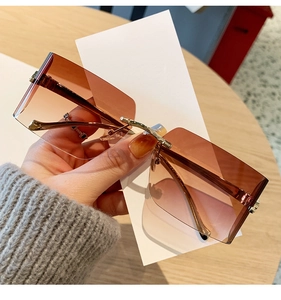 Detail of rimless square sunglasses with gradient brown lenses and gold leopard hardware