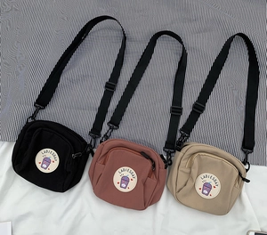 Vista detallada de los tres bolsos bandolera de lona con correas ajustables y parches