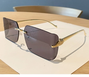 Close-up of gold metal temples with grain texture on rimless gradient sunglasses