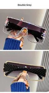 Macro detail of double grey gradient lenses and rhinestone-encrusted gold-trimmed sunglasses