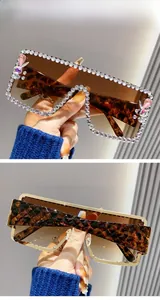 Close-up of oversized rhinestone sunglasses with double brown gradient lenses and leopard print
