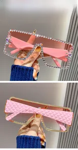 Close-up of oversized square sunglasses with diamond-encrusted frames and quilted temples