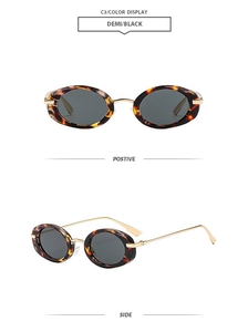 Detail of oval tortoiseshell sunglasses with slim gold metal temples on white background