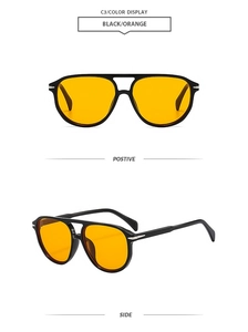 Detail view of aviator sunglasses with black frame and vibrant orange lenses and double bridge