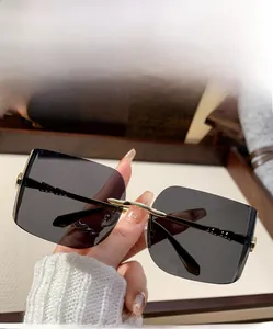 Detailed macro view of rimless square grey sunglasses with gold geometric temples