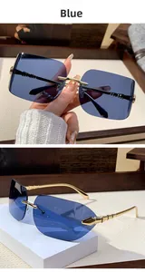 Close-up of frameless deep blue sunglasses with gold metal geometric temples on a white base
