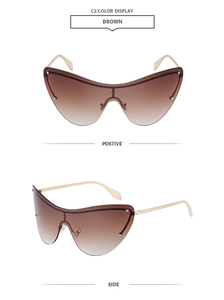 Close-up of brown gradient shield sunglasses with gold metal temples and stud details
