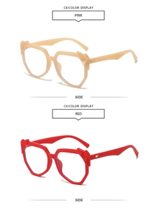 Side view of oversized geometric sunglasses in pink and red with wing-shaped metal accents