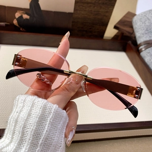 Retro rimless oval sunglasses with pink tinted lenses and gold metal frame for women