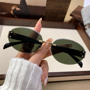 Rimless oval sunglasses with dark green lenses and gold metal temples for retro chic style