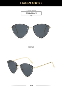 Close-up of geometric rimless sunglasses with gold metal frame and dark gray lenses