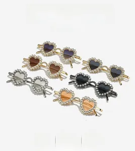 Detailed view of heart-shaped sunglasses with faux pearl-encrusted frames in various colors