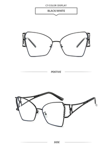 Dettaglio di occhiali da sole cat-eye neri con montatura in metallo traforato e aste geometriche