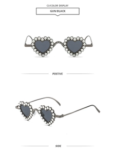 Detail view of heart-shaped sunglasses with gunmetal frame and crystal-encrusted edges