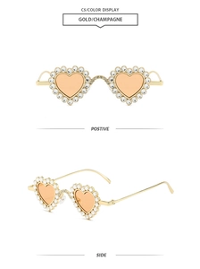 Detail of heart-shaped sunglasses with gold frames and sparkling rhinestones