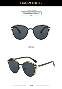 Détail de lunettes de soleil œil-de-chat rétro avec monture dorée et verres gris foncé