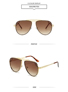 Detail view of gold aviator sunglasses with brown gradient lenses and metal double bridge