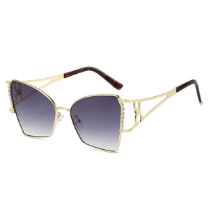 Occhiali da sole cat-eye in metallo con strass e lenti viola sfumate su sfondo bianco neutro