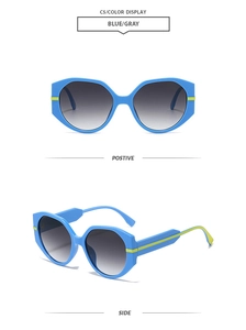 Detail view of large polygon blue sunglasses with yellow stripes and grey gradient lenses