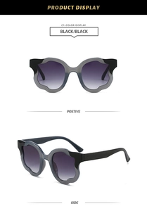 Detail of petal-shaped wave frame sunglasses with purple gradient lenses and black finish