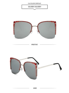 Detailansicht der silbernen randlosen Sonnenbrille mit roten Strasssteinen und grauen Gläsern