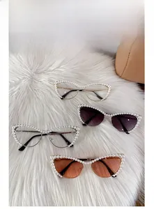 Detailed view of cat-eye sunglasses with pearl-embellished frames and gold metal temples