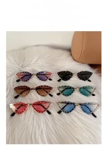 Detail of six assorted rhinestone cat-eye sunglasses on a white plush surface