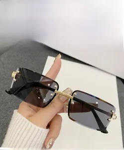 Detail of rimless rectangle sunglasses with gradient gray lenses and gold metal bridge