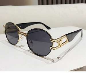 Detailed view of oval sunglasses with gold hollow frames and sleek double bridge design