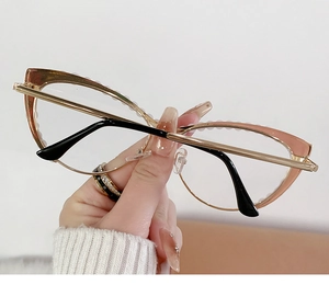 Detail of cat-eye sunglasses with gradient frames and gold metal temples in hand