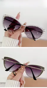 Detail of cat eye sunglasses with pearl-encrusted frame and purple gradient lenses
