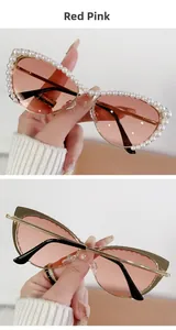 Detail of cat-eye sunglasses with white pearls on red pink lenses and gold metal frame