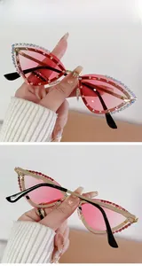 Detail of rimless cat-eye sunglasses with pink gradient lenses and rhinestone accents