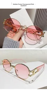 Detail view of oval gold metal sunglasses with pink gradient lenses and cutout hinges