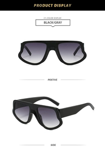 Detail showing irregular wavy frame design and gradient gray lenses on black sunglasses