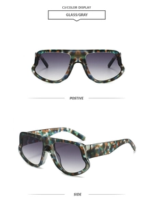 Detail view of large irregular frame sunglasses with blue-green camouflage tortoiseshell pattern