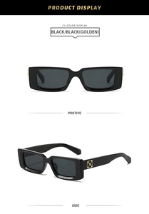 Detail of square black sunglasses with golden cross hinge and high-quality dark lenses