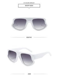 Detail view of white irregular oversized sunglasses with gray gradient lenses