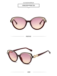 Détail de lunettes de soleil œil de chat bordeaux avec chaîne dorée et verres dégradés rose