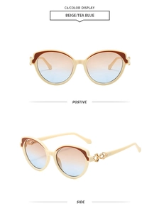 Détail de lunettes de soleil œil-de-chat beige avec verres bleu thé et décor doré