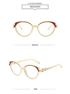 Détail de lunettes œil-de-chat beige avec charnières dorées et accents marrons