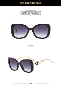 Detail of cat eye sunglasses featuring gold hollow heart temples and gradient gray lenses