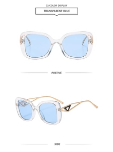 Detail view of transparent blue cat-eye sunglasses with gold metal heart-shaped hinges