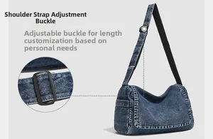 Detail of adjustable strap and washed denim texture on a crescent messenger bag
