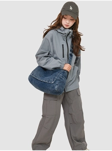 Detail of blue denim messenger bag with wide shoulder strap and vintage washed texture